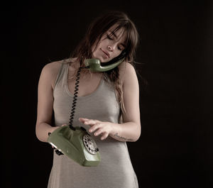 Young woman wearing mask against black background