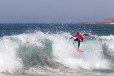 Man surfing in sea against sky
