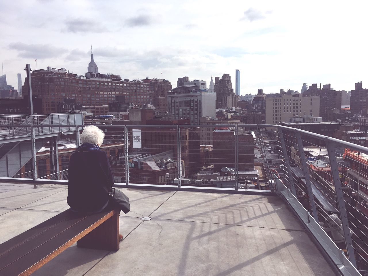 REAR VIEW OF WOMAN IN CITY AGAINST BUILDINGS