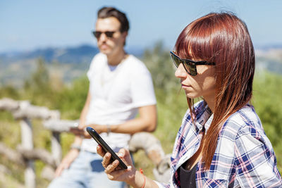 Young couple of adults writes on their mobile phone