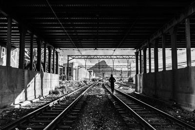 Rear view of person balancing on railroad track