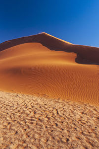 Scenic view of desert against clear blue sky