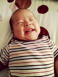 Portrait of cute baby girl on bed at home