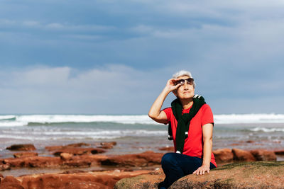 Full length of teenage girl at beach against sky