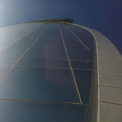 Low angle view of modern building against clear blue sky