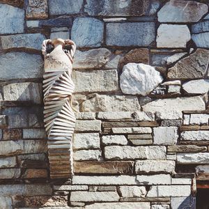 Low section of person standing against stone wall