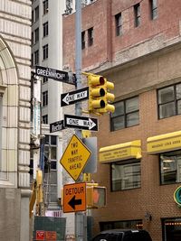 Low angle view of road sign against buildings in city