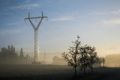 Electricity pylon against sky during sunset