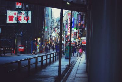 People walking on illuminated street at night