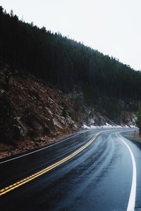 Road passing through landscape against clear sky