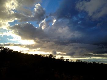 Low angle view of silhouette landscape against dramatic sky