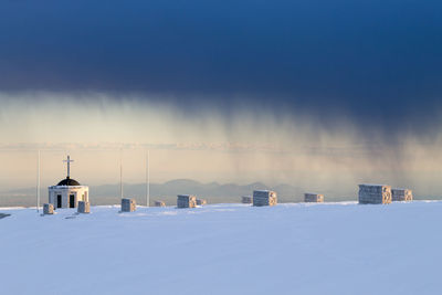 Snow covered land against sky