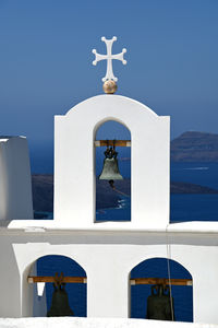 Bell hanging by sea against clear sky