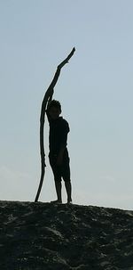Silhouette man standing on beach against clear sky