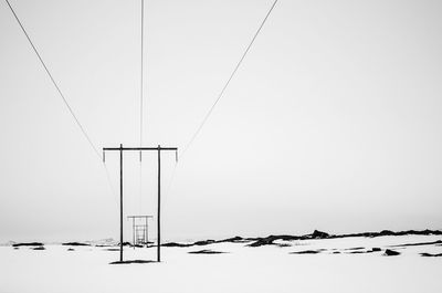 Low angle view of power lines against clear sky