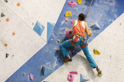 Low angle view of woman climbing on wall