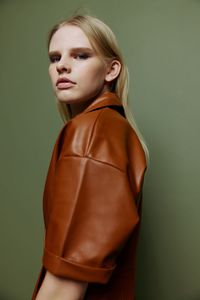 Young woman standing against wall