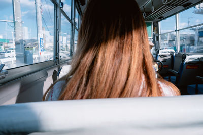 Rear view of woman sitting in bus