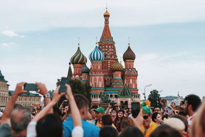 Group of people in front of buildings against sky