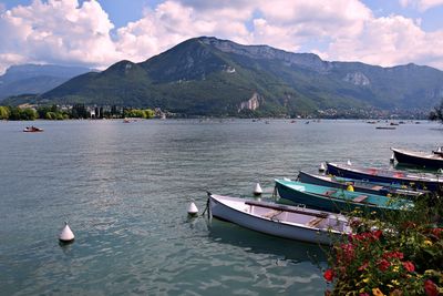 Sailboats moored in lake against sky