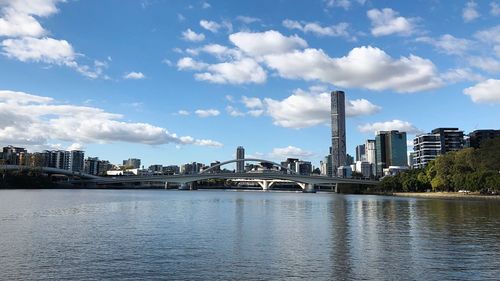 Scenic view of river by buildings against sky