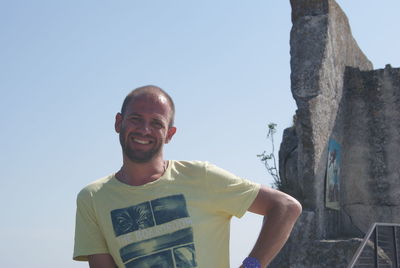 Portrait of smiling man standing against sky