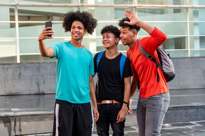 Multiethnic friends taking selfie in the street