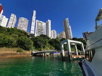 Scenic view of river by buildings against sky