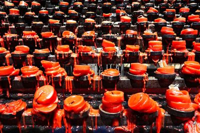 Full frame shot of melting orange candles in church