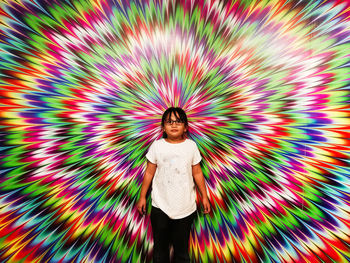 Portrait of girl standing against colorful wall