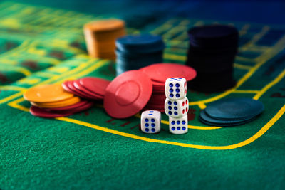 Close-up of gambling chips and dices on table at casino