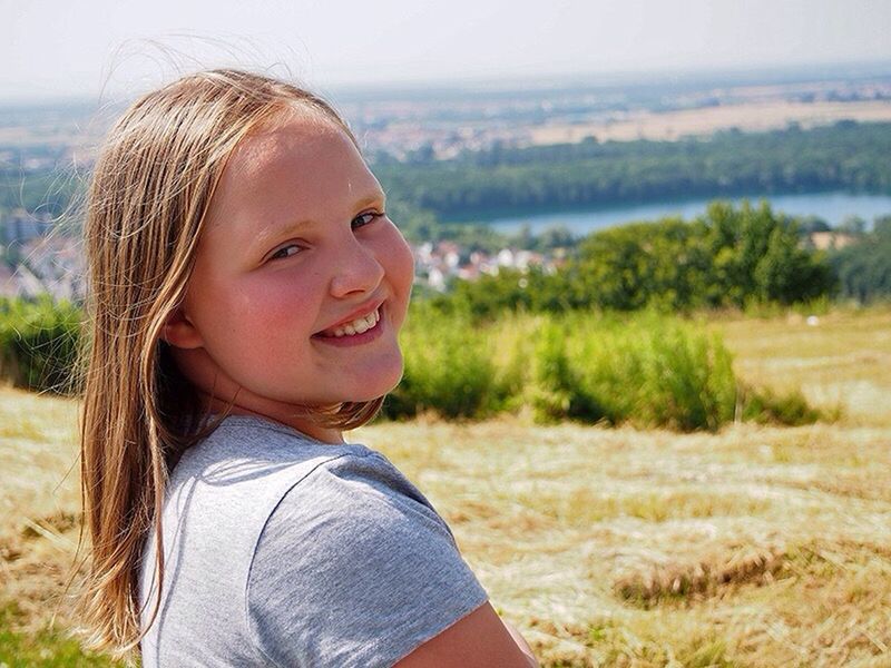 focus on foreground, lifestyles, person, leisure activity, casual clothing, field, grass, headshot, childhood, looking away, elementary age, smiling, nature, boys, day, sky, close-up, outdoors