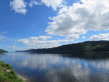 Scenic view of calm lake against cloudy sky
