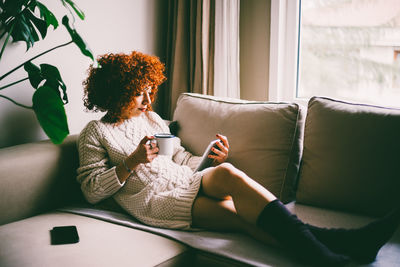 Woman sitting on sofa at home