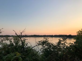 Scenic view of lake against clear sky during sunset