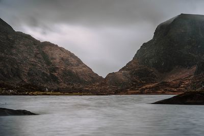 Scenic view of sea and mountains against sky