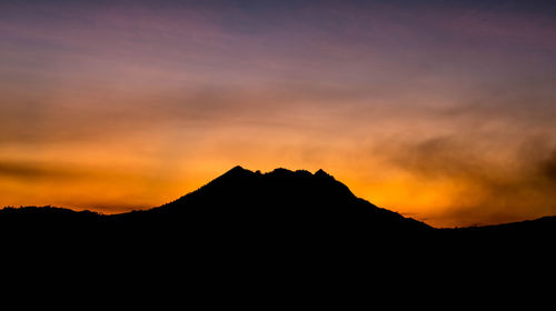 Scenic view of silhouette mountains against sky during sunset