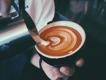 Close-up of hand holding coffee cup