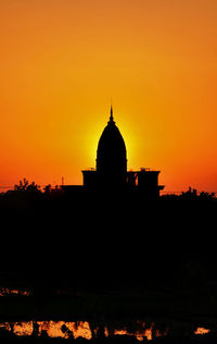 Silhouette of building against sky at sunset