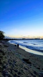 People on beach against clear sky