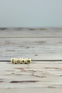 Close-up of text on table against sky