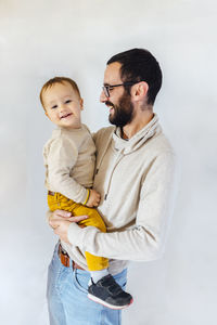Young father with his son in arms on white background. father and baby concept.