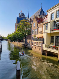 River amidst buildings in city against sky