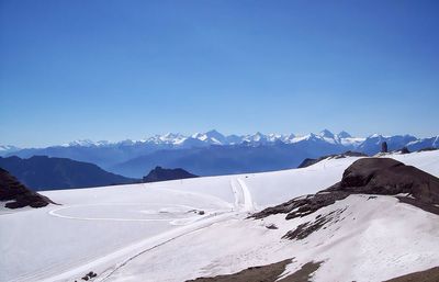 Scenic view of snowcapped mountains against blue sky