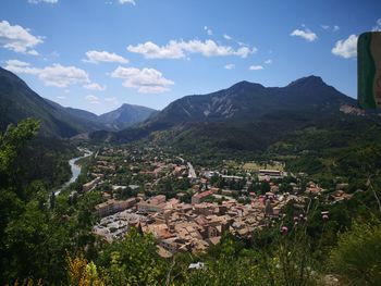 Aerial view of townscape by mountains against sky