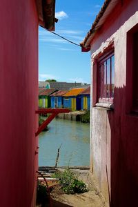 Houses by water against sky