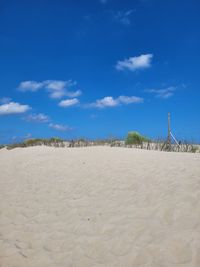 Scenic view of beach against blue sky