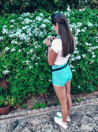 Full length of woman standing on flowering plants