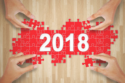 Cropped hands solving puzzles on wooden table