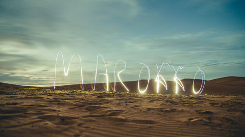 Panoramic shot of text on beach against sky